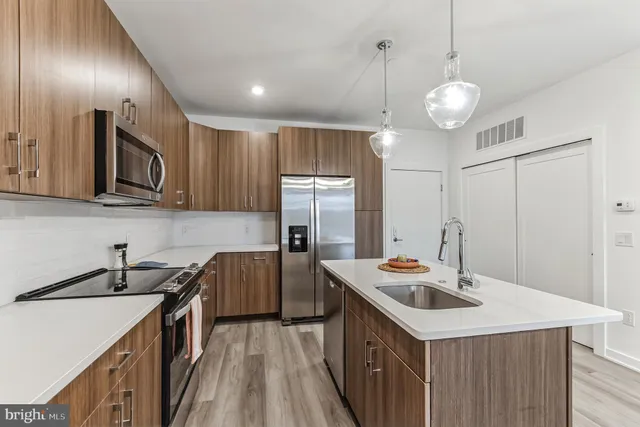 a kitchen with stainless steel appliances granite countertop a sink a stove and a refrigerator