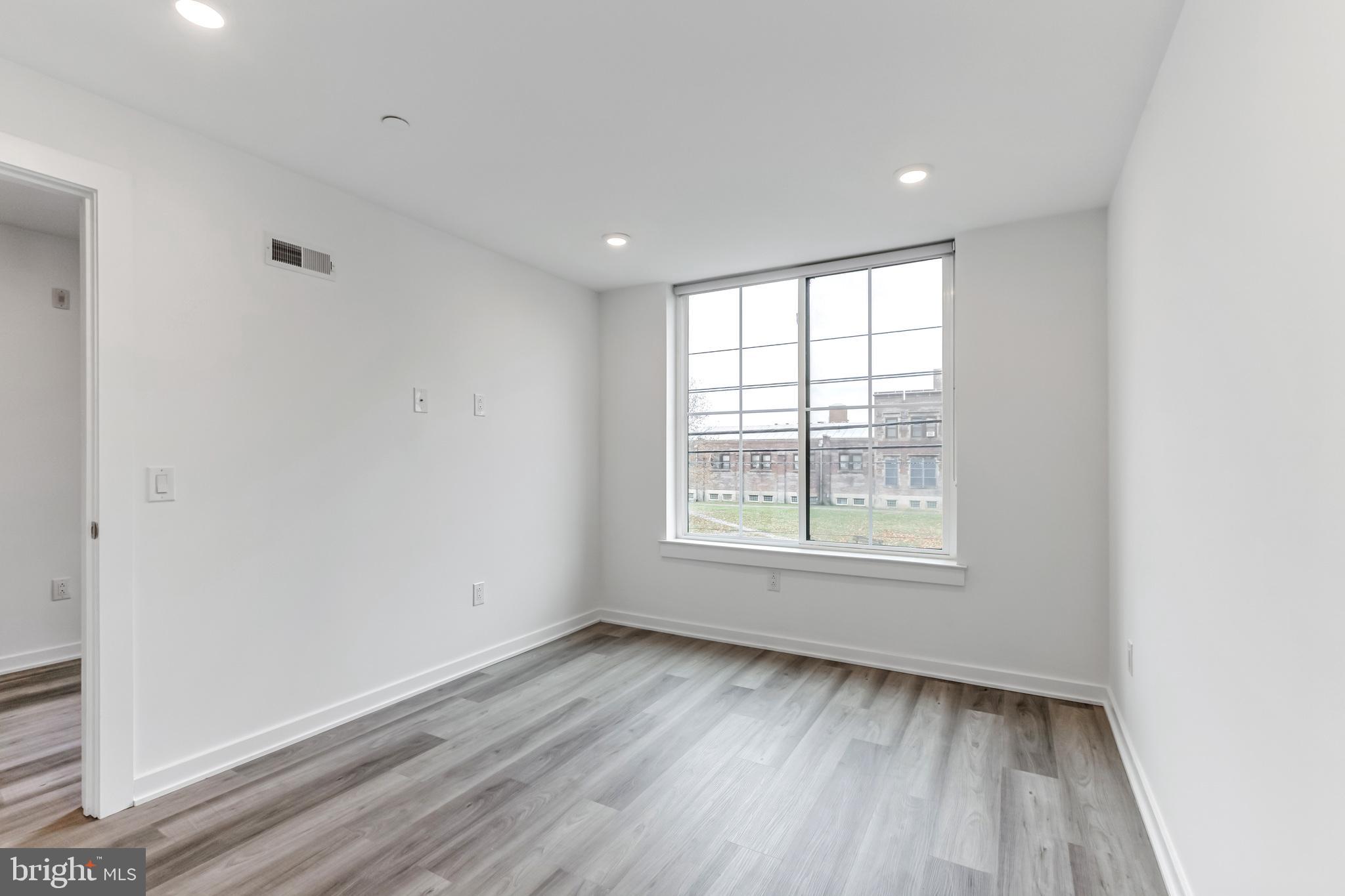 5801 Ridge Avenue, Unit 201 Philadelphia, PA 19128 - Photo 9 of 26 an empty room with wooden floor and windows