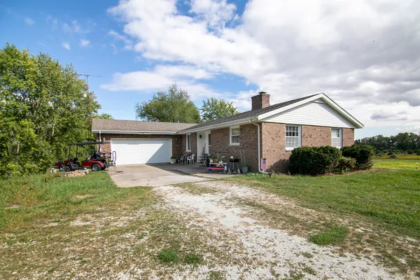 a view of a house with a yard and large tree