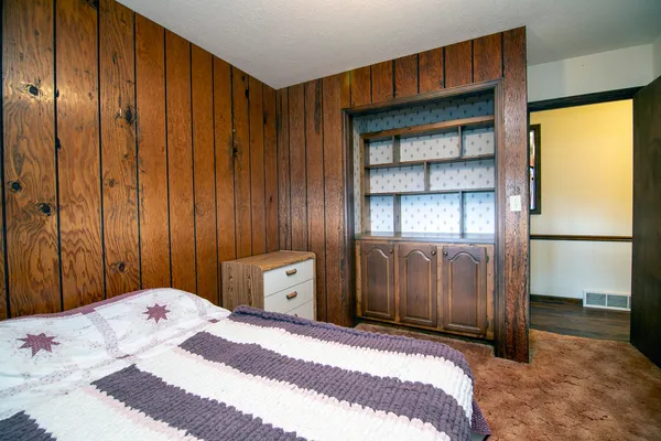 a bedroom with a large bed and a chandelier