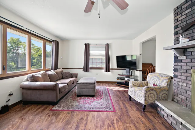 a living room with furniture flat screen tv and a large window