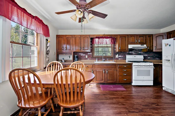 a kitchen with stainless steel appliances a refrigerator sink and wooden floor