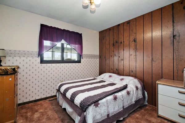 a bedroom with a bed and a window
