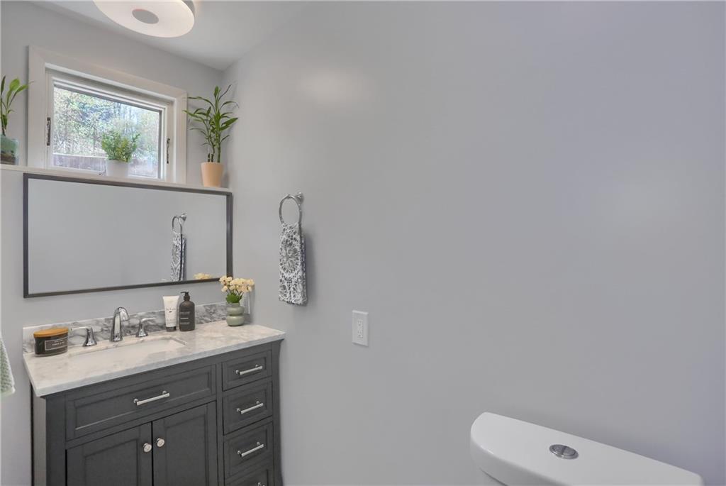 5216 Verona Road Verona, PA 15147 - Photo 29 of 42 a bathroom with a toilet a sink a mirror and a window