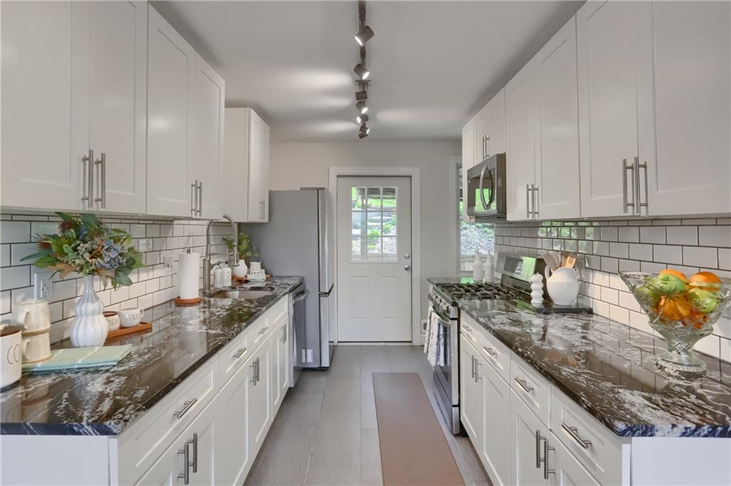 5216 Verona Road Verona, PA 15147 - Photo 32 of 42 a kitchen with granite countertop a sink a counter space appliances and cabinets