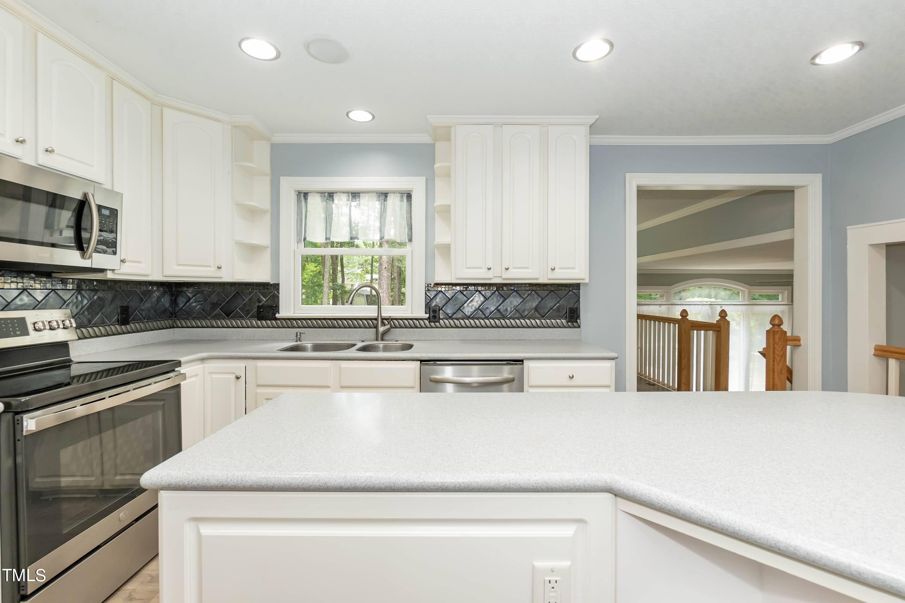 9209 Oneal Road Raleigh, NC 27613 - Photo 18 of 53 a kitchen with stainless steel appliances granite countertop a stove a sink and a refrigerator