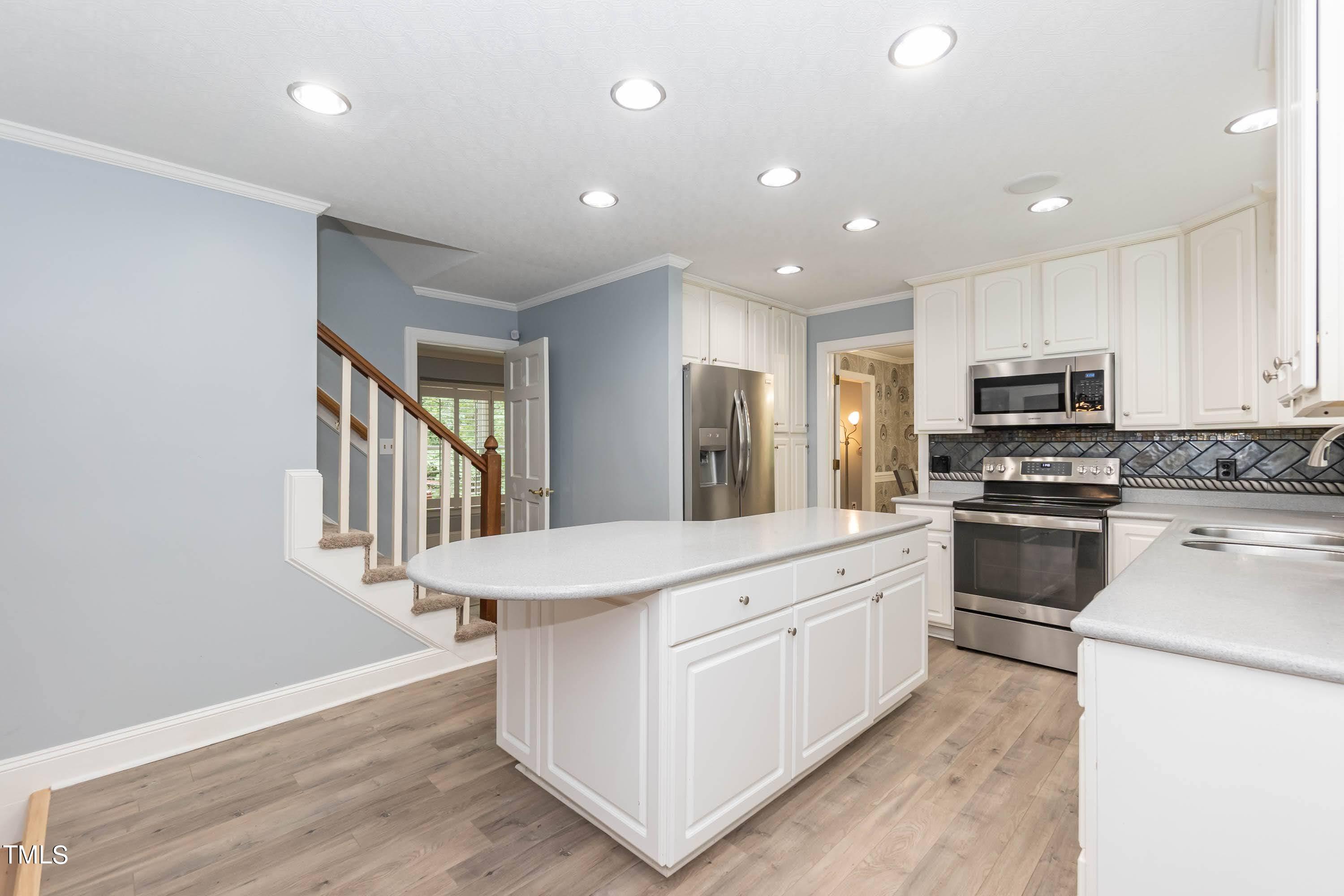 9209 Oneal Road Raleigh, NC 27613 - Photo 20 of 53 a kitchen with stainless steel appliances kitchen island granite countertop a stove top oven a sink and a refrigerator