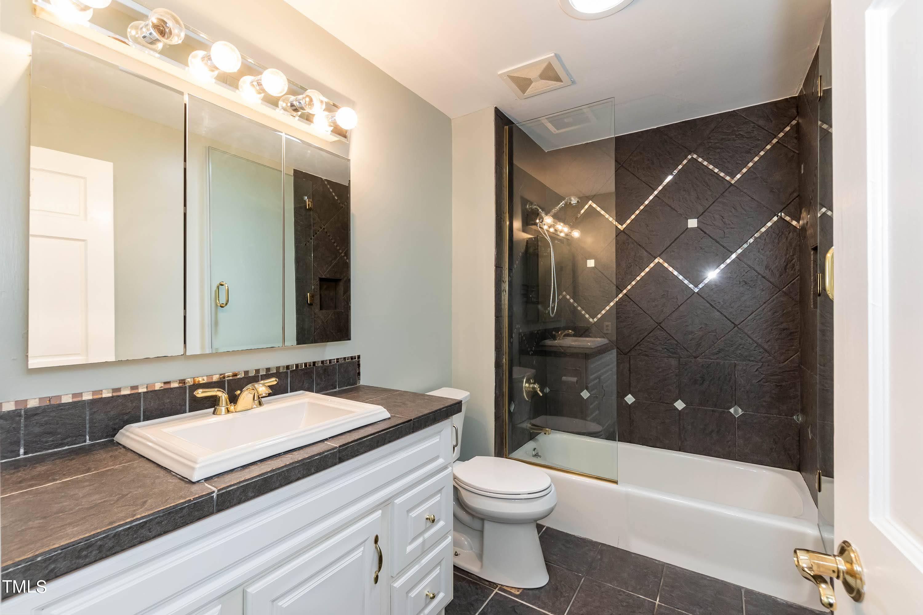 9209 Oneal Road Raleigh, NC 27613 - Photo 40 of 53 a bathroom with a sink a toilet and shower