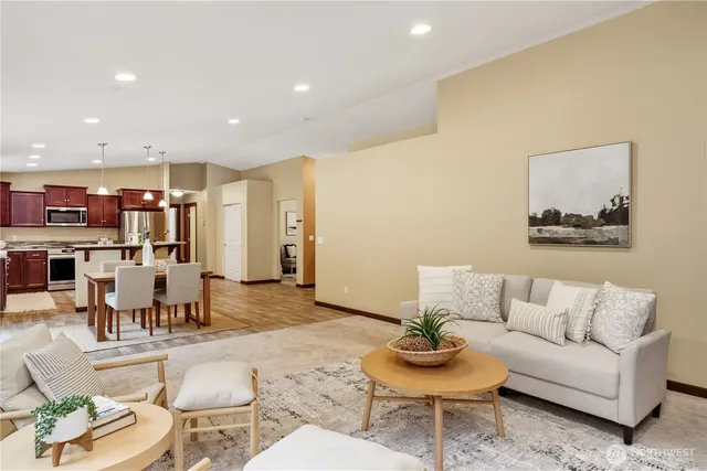 a living room with furniture and a dining table with kitchen view