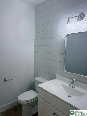 a bathroom with a sink vanity granite and toilet