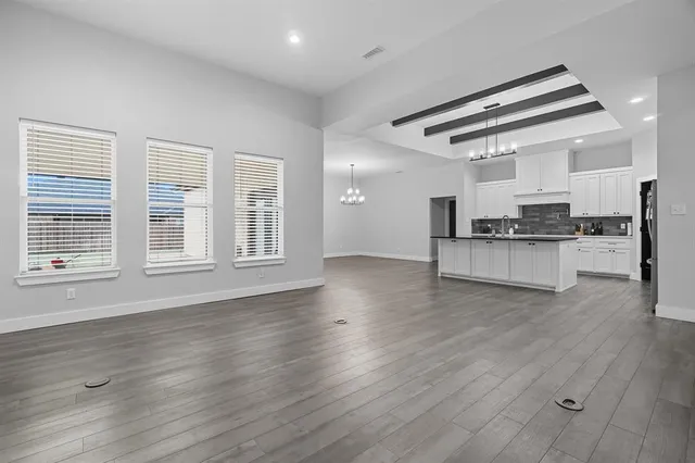 a view of a room with wooden floor and chandelier