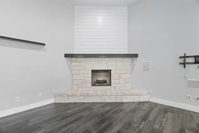 an empty room with wooden floor ceiling fan and windows