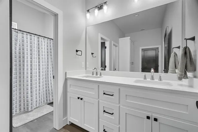 a large bathroom with a double vanity sink a mirror and a shower