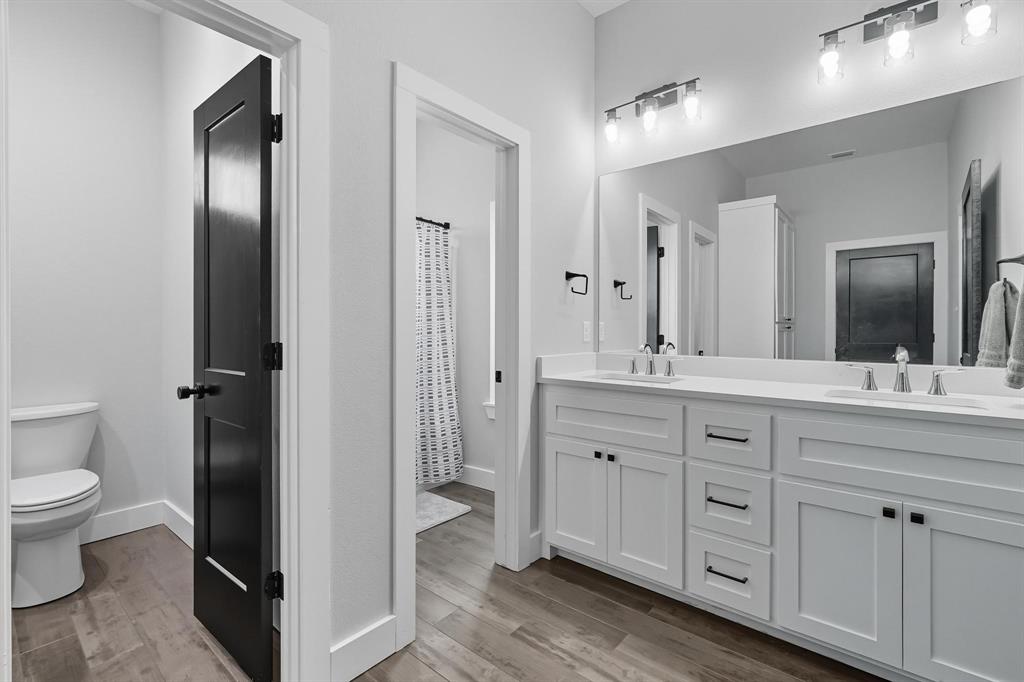 6502 Randy Avenue Abilene, TX 79606 - Photo 19 of 37 a spacious bathroom with a double vanity sink a mirror and a toilet