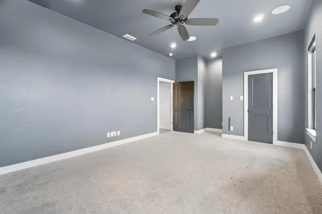 an empty room with windows and flat screen tv