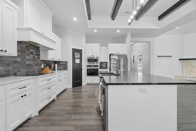a kitchen with stainless steel appliances a refrigerator sink and cabinets