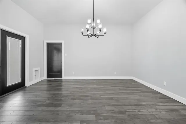 a view of a kitchen with refrigerator and wooden floor