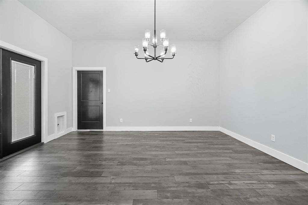 6502 Randy Avenue Abilene, TX 79606 - Photo 8 of 37 a view of an empty room with chandelier fan and wooden floor