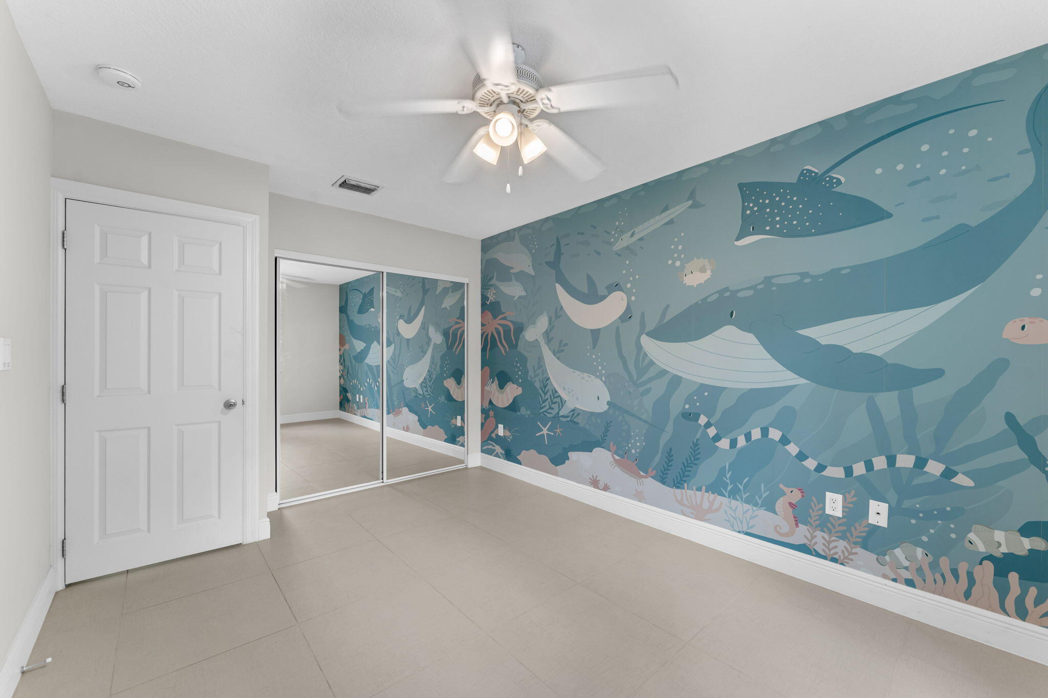 67 Jewfish Avenue Key Largo, FL 33037 - Photo 14 of 43 a view of a hallway with a chandelier fan and windows