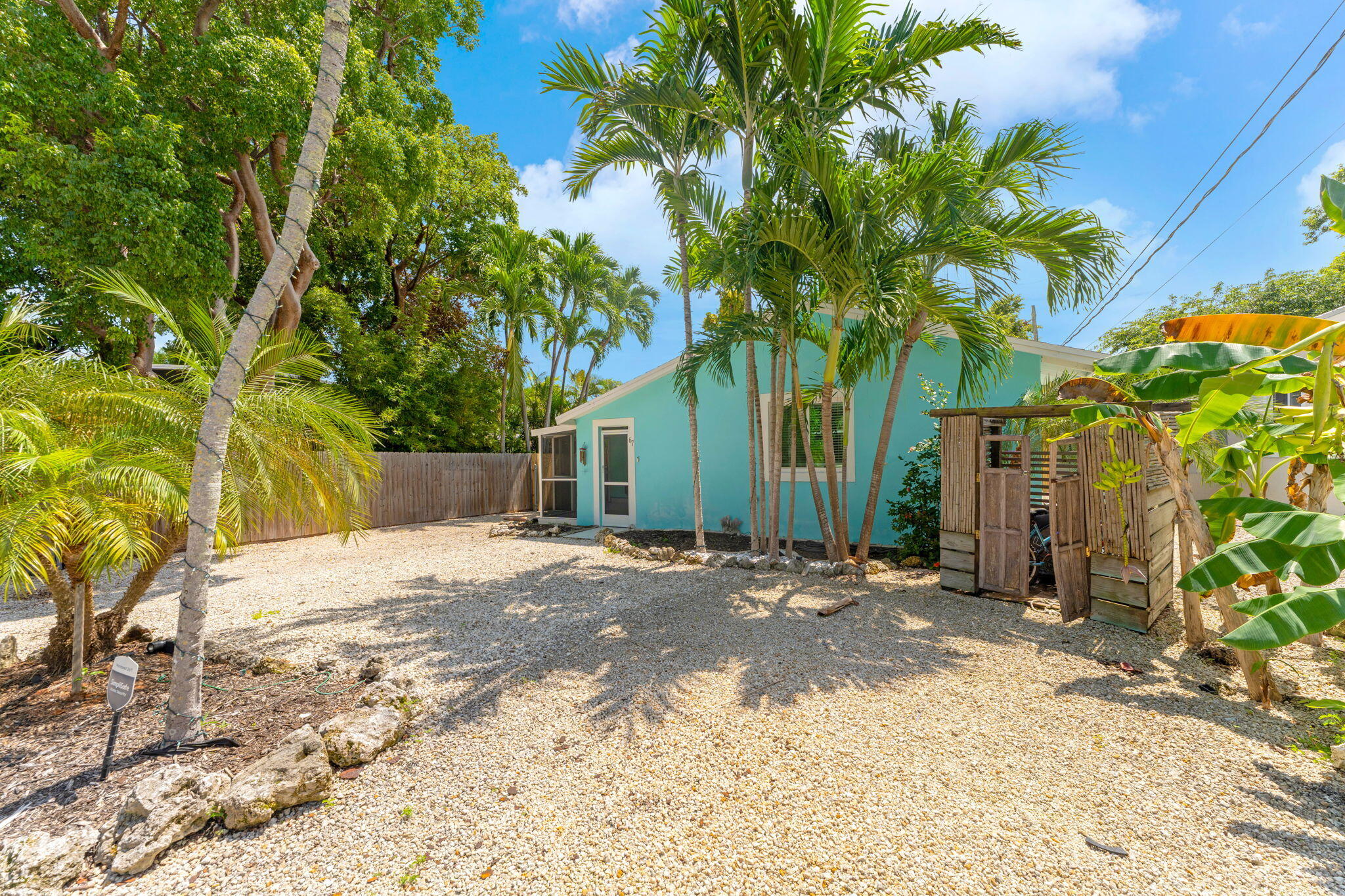 67 Jewfish Avenue Key Largo, FL 33037 - Photo 2 of 43 a backyard of a house with table and chairs