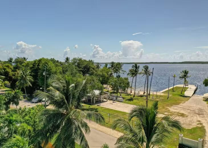 67 Jewfish Avenue Key Largo, FL 33037 - Photo 37 of 43 a bed room with large bed and a chandelier