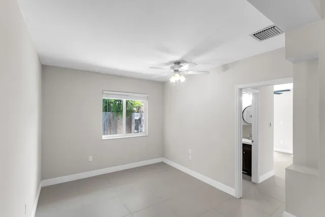 a view of an empty room with a chandelier fan
