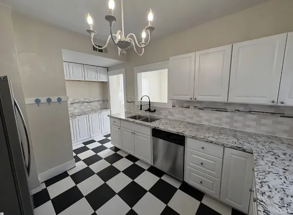 a kitchen with granite countertop stainless steel appliances a sink and cabinets
