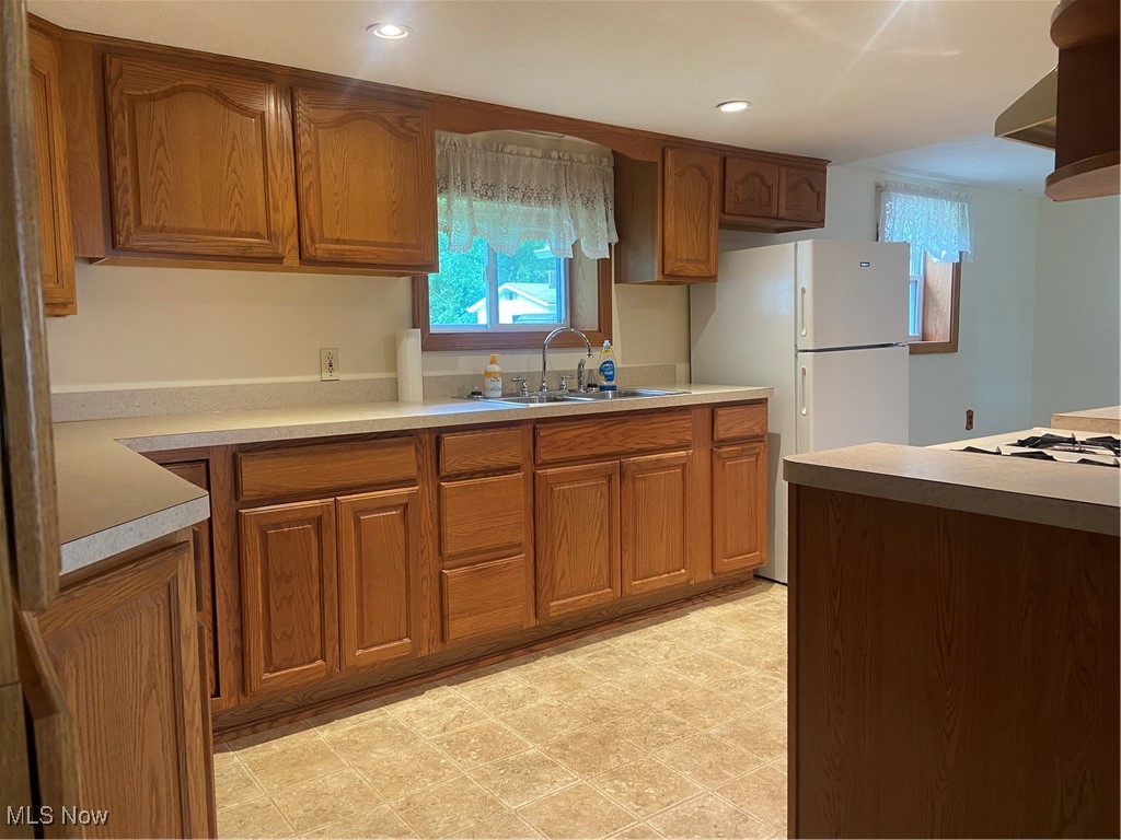 14092 Hatfield Road Rittman, OH 44270 - Photo 12 of 38 Kitchen with brown cabinets, refrigerator, light countertops, plenty of natural light, and recessed lighting