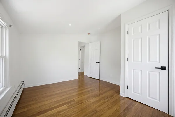a view of empty room with wooden floor
