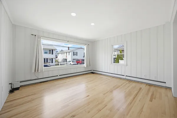 a view of a living room and kitchen with furniture and wooden floor