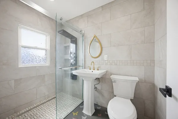 a bathroom with a sink a toilet and a mirror