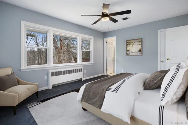 an empty room with ceiling fan and windows