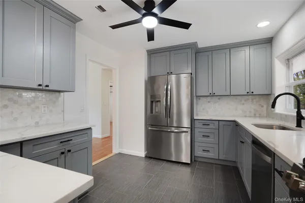 a kitchen with stainless steel appliances a refrigerator sink and cabinets