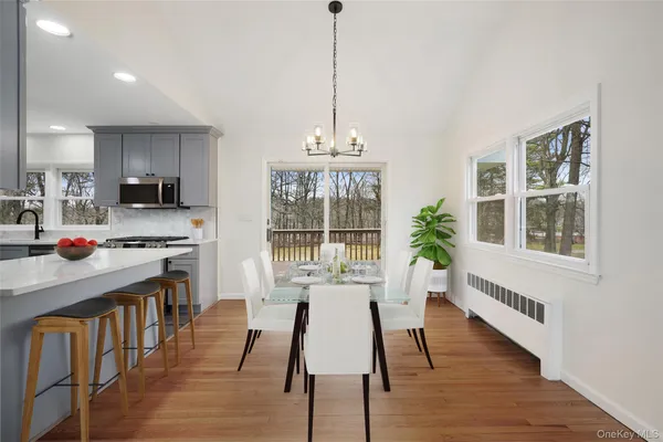 a dining room with wooden floor and a chandelier
