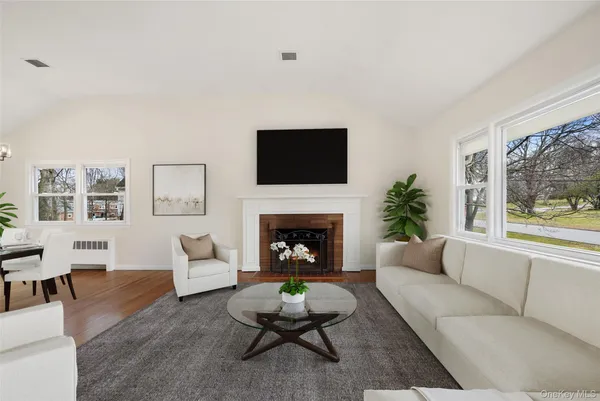 a living room with furniture a fireplace and a large window