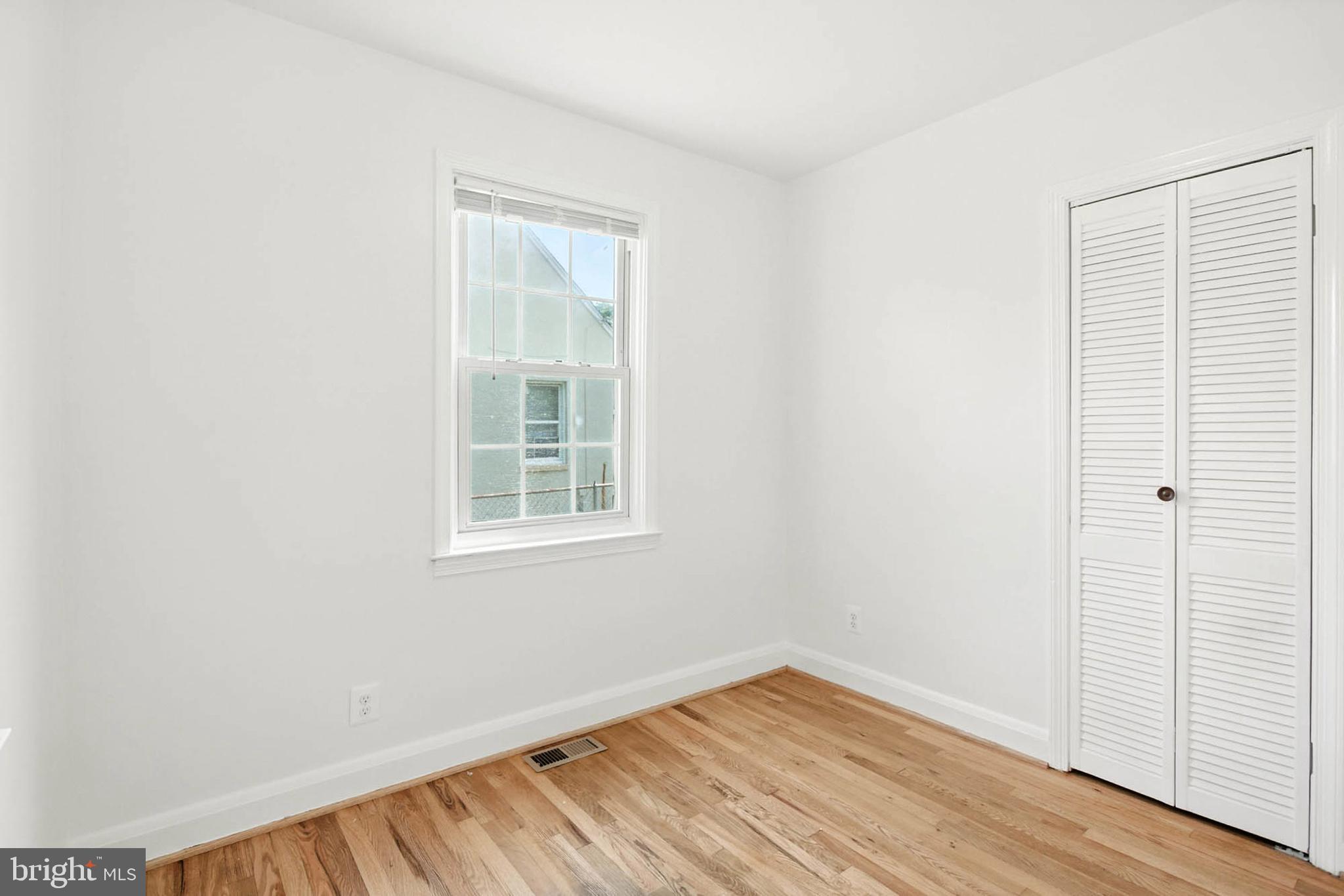 56 Ridgemoor Road Essex, MD 21221 - Photo 16 of 27 an empty room with wooden floor and windows
