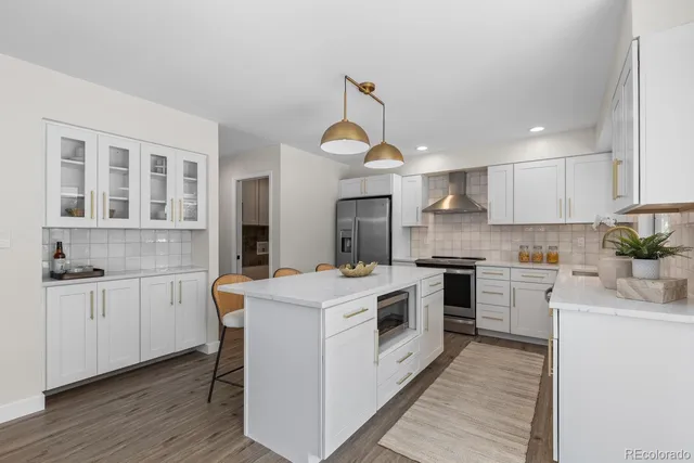 a kitchen with granite countertop a sink a stove top oven and cabinetry