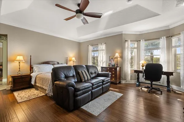 a bedroom with a bed wooden floor and window