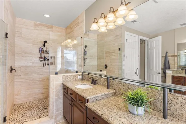a bathroom with a granite countertop toilet sink and mirror