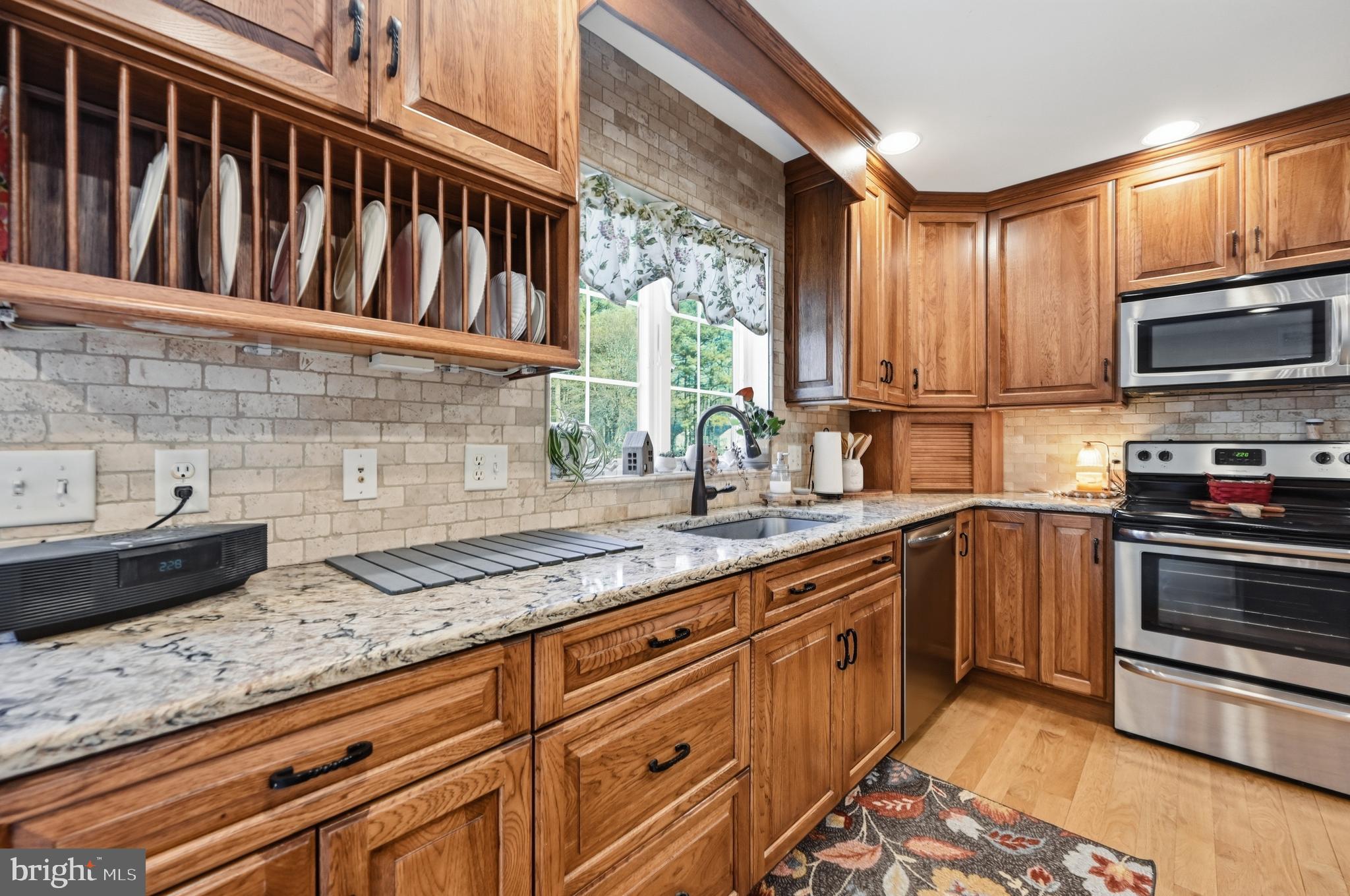 18981 Kenney Road Delmar, DE 19940 - Photo 11 of 31 a kitchen with granite countertop a stove a sink and a microwave