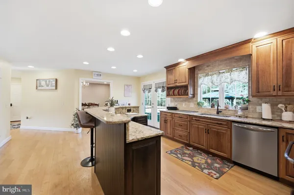 a kitchen with stainless steel appliances granite countertop a sink a stove and a refrigerator