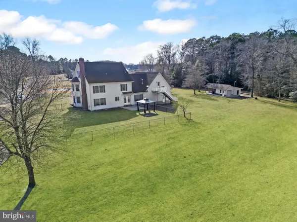 a view of a house with a big yard and large trees