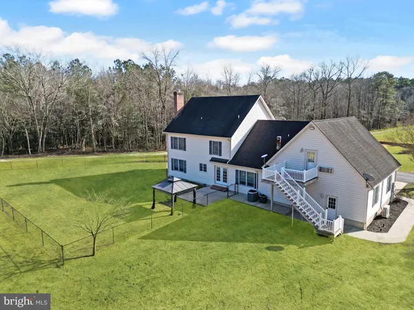 a view of a house with a big yard and a sitting area
