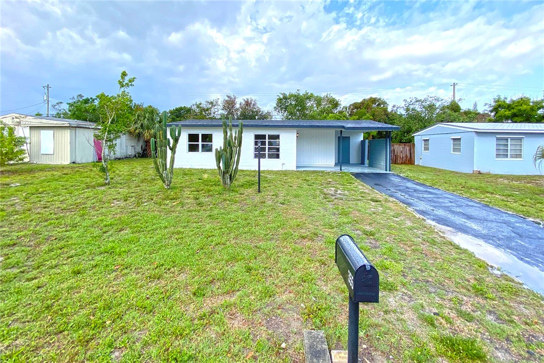 355 6th Road Southwest Vero Beach, FL 32962 - Photo 5 of 23 a front view of a house with a yard and trees