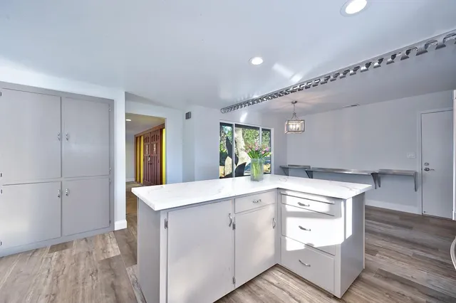 a large kitchen with stainless steel appliances kitchen island granite countertop a refrigerator and a stove top oven