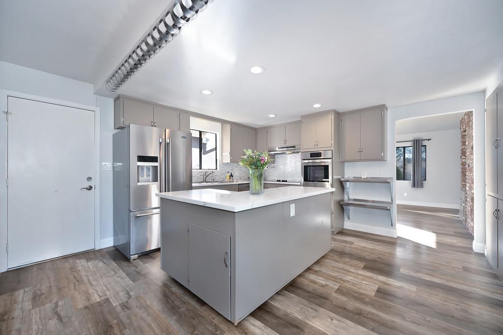 2298 Pinon Road Rescue, CA 95672 - Photo 23 of 67 a large kitchen with stainless steel appliances kitchen island granite countertop a refrigerator and a stove top oven