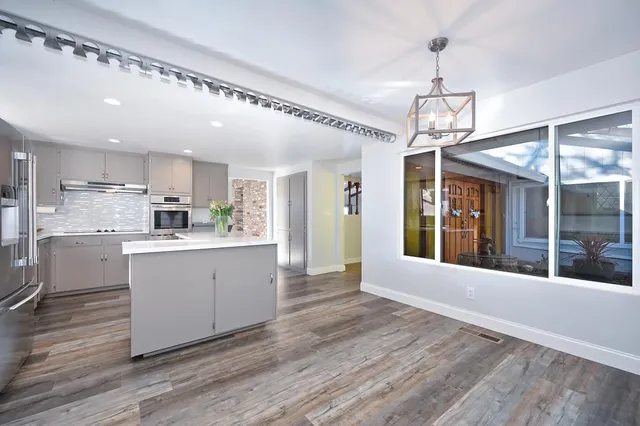 a view of an empty room with wooden floor and closet