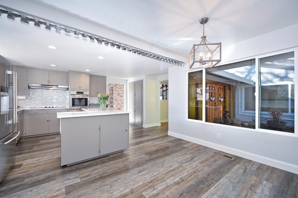2298 Pinon Road Rescue, CA 95672 - Photo 28 of 67 a large white kitchen with center island wooden floor and stainless steel appliances