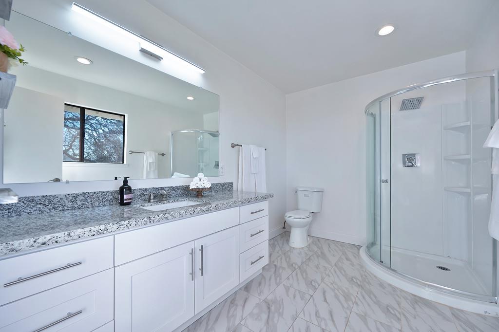 2298 Pinon Road Rescue, CA 95672 - Photo 38 of 67 a spacious bathroom with a granite countertop sink a toilet a shower and a mirror