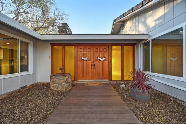 a view of an empty room with wooden floor and a ceiling fan